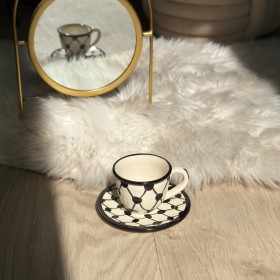 فنجان قهوة حلوة مع يد نقشة الكوفية