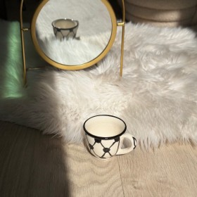 فنجان قهوة حلوة مع يد نقشة الكوفية